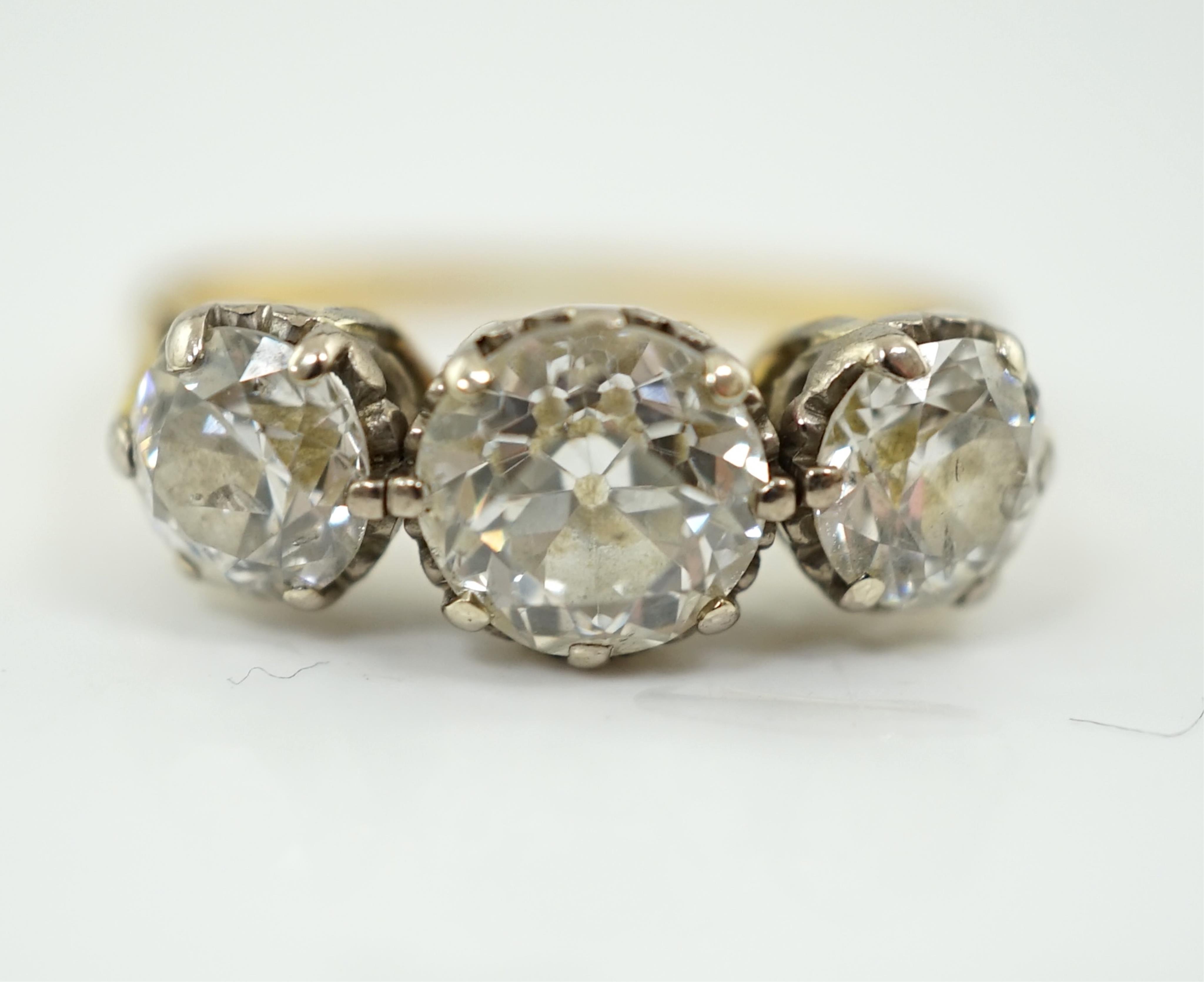 An unmarked gold and three stone diamond set ring